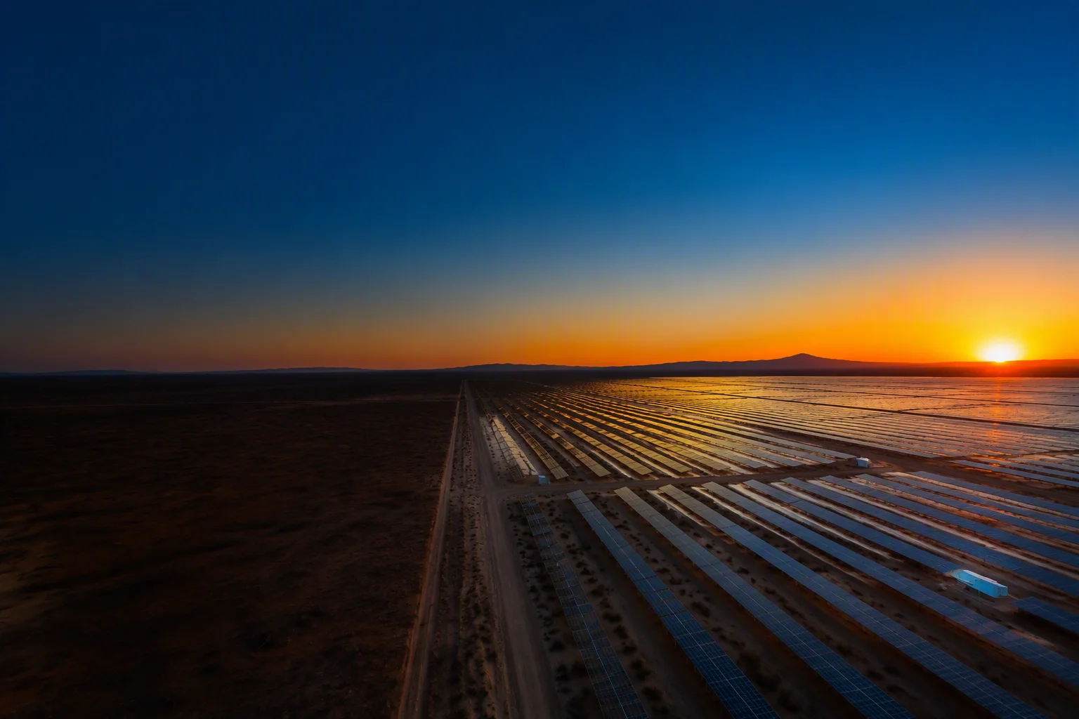 Aerial view of a bifacial solar farm at sunset