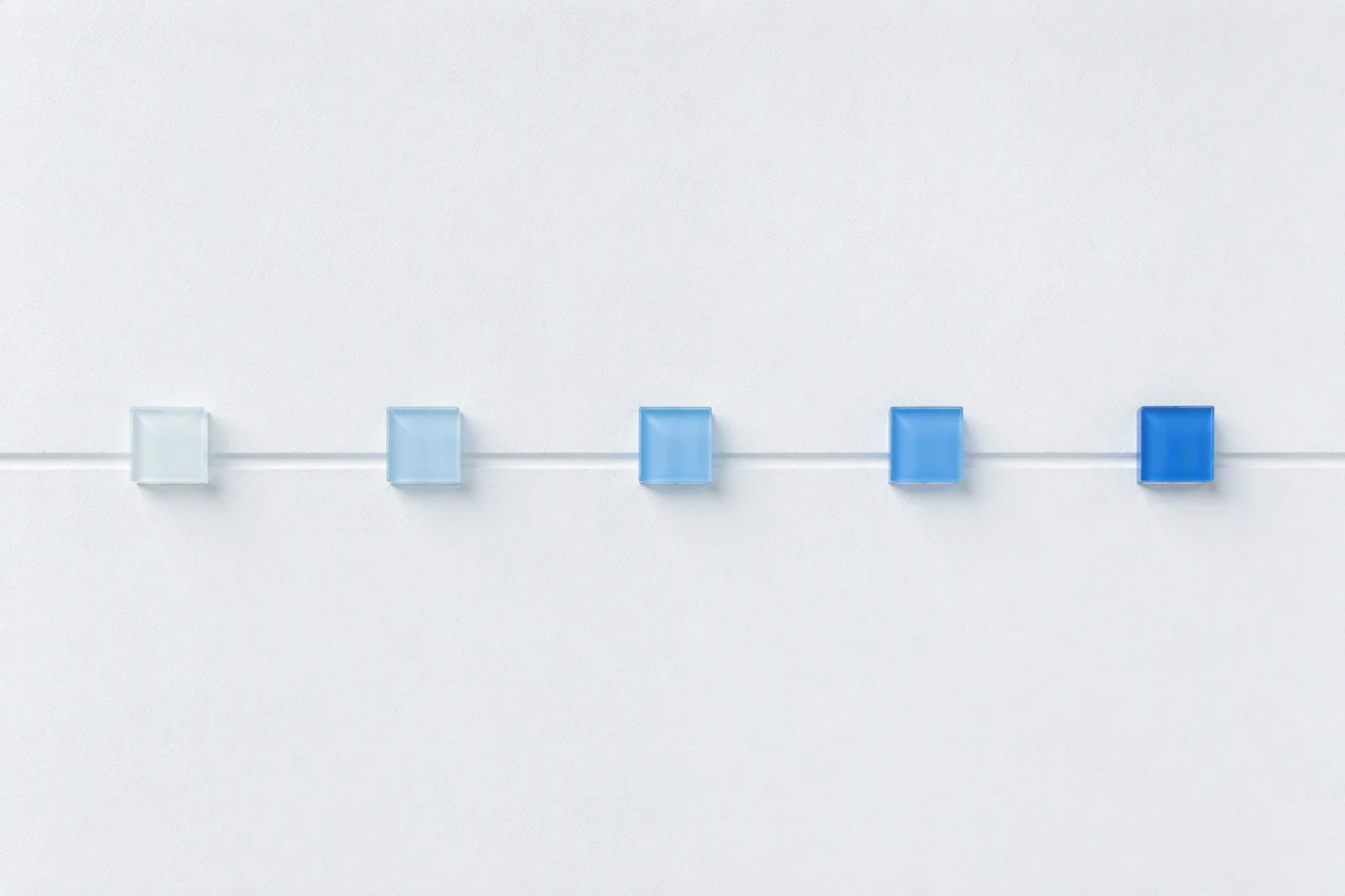 Glass tiles in graduated ice-blue tints along a milestone line